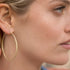 Dominique Cohen 18k gold 2-inch hoop earrings<br>shown up close, on model <span class='visuallyhidden'>Phone or text 323-404-2959 for shopping assistance</span>