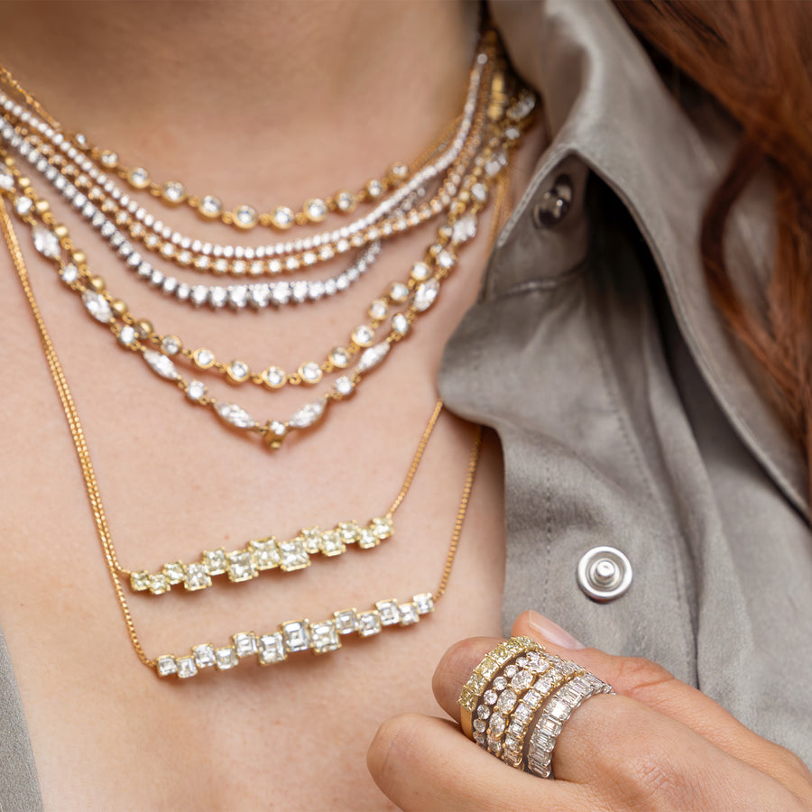 Swoop, a Dominique Cohen diamond + yellow diamond jewelry + apparel collection worn by a lovely redhead wearing a sage-hued limited edition designer beanie and silk shirt; shop help at 760-978-9297