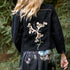 Dominique Cohen black denim structure jacket with floral and other artisan-stitched up-styling<br>shop the look > effortless elegance<span class='visuallyhidden'>; shop help at 760-978-9297.</span>